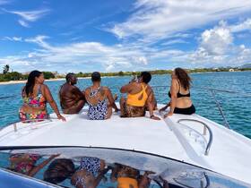 A group of friends enjoys a sunny day on a boat, taking in the beautiful views and celebrating together — perfect for memorable outings on the water.