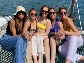 A joyful group of friends celebrates aboard a yacht, raising their glasses in a toast — perfect for memorable gatherings and special occasions on the water.