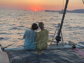 A couple enjoys a romantic sunset view from the deck of a catamaran, creating a perfect backdrop for memorable moments on the water.