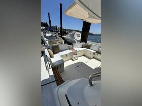 A spacious and inviting interior seating area on a boat, featuring comfortable cushions and a clean deck, perfect for relaxing while enjoying the water.