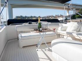 A stylish interior view of a boat's lounge area featuring comfortable seating and a table set with champagne and glasses, perfect for relaxing on the water.