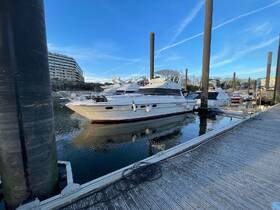 A sleek yacht docked at the marina, showcasing its elegant design against a clear blue sky — perfect for luxury boating experiences.