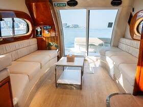 A cozy interior view of a boat's lounge area, featuring comfortable seating and large windows that offer stunning views of the water, perfect for relaxation during a cruise.