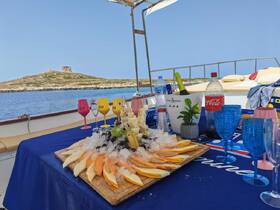 A beautifully arranged platter of fresh fruits and drinks on a boat, perfect for enjoying a relaxing day on the water with friends or family.
