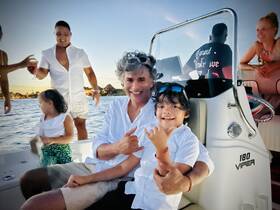 A joyful family moment aboard a boat, with adults enjoying cocktails and children playing, capturing the essence of a fun-filled day on the water.