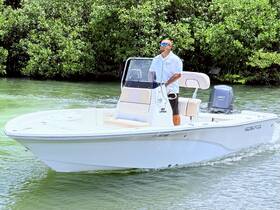 A captain navigates a sleek boat through lush mangroves, showcasing the beauty of a day on the water.