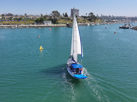A beautiful sailing yacht navigates through clear turquoise waters, showcasing the vibrant scenery of Oceanside — perfect for a day on the water.