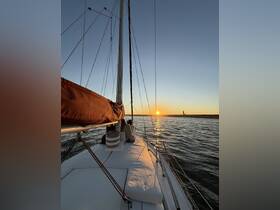 A serene sunset view from the deck of a sailboat, where a couple enjoys a romantic sailing experience as the sun dips below the horizon.