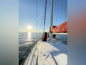Guests enjoy a serene sunset sailing experience on a yacht, capturing the perfect moment of relaxation and camaraderie on the water.