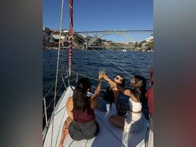 A group of friends celebrates with cocktails on the deck of a yacht, enjoying stunning views of the bridge and waterfront — perfect for memorable outings and special occasions.