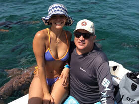 A couple enjoys a sunny day on the water, showcasing a perfect moment of relaxation and fun while swimming in the ocean.