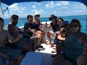 A lively group enjoys drinks aboard a boat, capturing the essence of a fun-filled day on the water with friends.