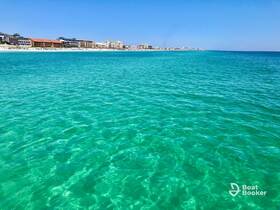 A scenic view of clear turquoise waters and a distant shoreline, perfect for showcasing beautiful coastal destinations.
