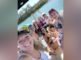 A lively group of friends enjoys a fun day on the water, capturing joyful moments aboard a boat — perfect for celebrations and summer adventures.