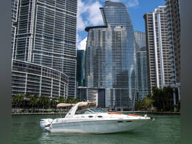 A sleek speedboat navigates through the waters of a bustling city, showcasing modern architecture in the background — perfect for urban boating adventures.