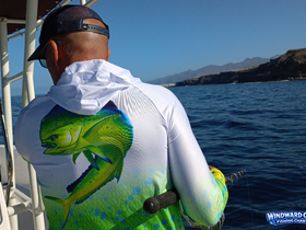 An angler prepares to reel in a catch while fishing on a boat, showcasing the thrill of ocean adventures. Perfect for fishing enthusiasts looking for charter experiences.