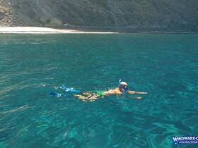 A snorkeler explores the vibrant underwater world in crystal-clear waters, showcasing the beauty of marine life and adventure on the water.