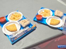 A colorful display of snacks and meals served on a boat, featuring chips, salsa, and a savory omelet — perfect for enjoying while out on the water.