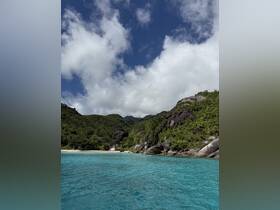 A stunning view of a secluded beach surrounded by lush greenery and rocky cliffs, showcasing the beauty of nature in a tropical paradise.