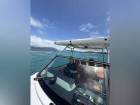 A view of the helm inside a boat, featuring a person steering and comfortable seating, perfect for navigating the beautiful waters.