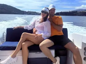 A couple enjoys a romantic moment on a boat, surrounded by beautiful scenery — perfect for a day out on the water.
