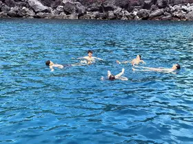 A group of friends enjoys a refreshing swim in crystal-clear blue waters, perfect for a fun day out on the boat.