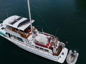 Aerial view of a yacht with guests on board engaging in activities, showcasing the perfect setting for a day on the water.