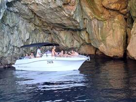 A lively group enjoys a boat ride near a stunning cave, capturing the essence of adventure and fun on the water.