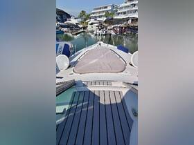 A view of the spacious interior of a boat, showcasing the seating area and helm, perfect for relaxing while cruising.