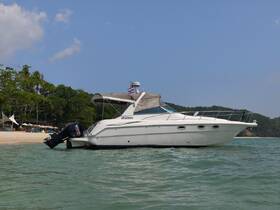 A sleek yacht named 'Apsheron' docked in clear waters, surrounded by lush greenery and sandy beaches, perfect for a day of relaxation on the water.