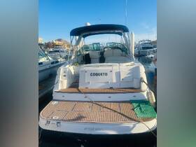 A clear view of the back of the 'Coqueto' yacht docked at the marina, showcasing its sleek design and wooden deck.