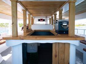 Interior view of a boat's cabin featuring wooden accents and seating, showcasing a comfortable space for guests to relax while enjoying their time on the water.