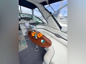 A cozy interior view of a boat's cabin featuring a stylish seating area and a table adorned with fresh oranges, perfect for relaxing moments on the water.