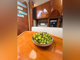 A cozy interior view of a boat cabin featuring a bowl of fresh green grapes on a polished table, perfect for enjoying snacks while cruising.
