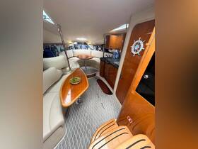 Interior view of a stylish boat cabin featuring comfortable seating and a dining area, perfect for relaxing and enjoying meals while on the water.