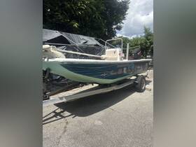 A side view of a fishing boat parked on a trailer, showcasing its sleek design and various stickers — perfect for anglers looking for their next adventure.