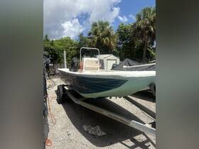 A classic boat on a trailer, surrounded by lush greenery, showcasing its structure and design in a serene outdoor setting.