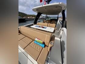 A stylish interior view of a boat's seating area, featuring plush cushions and a dining table, perfect for relaxing and enjoying the journey.