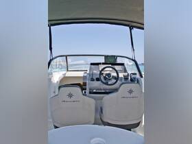 A sleek view of the helm area inside a Jeanneau boat, showcasing modern seating and navigation equipment, perfect for a day on the water.