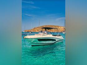 A sleek speedboat navigates through crystal-clear waters, showcasing its stylish design against a picturesque island backdrop.