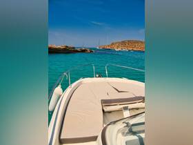 A stunning view from the front of a speedboat cruising through crystal-clear turquoise waters, showcasing the beautiful coastline and nearby boats.