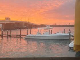 A sleek speedboat docked at sunset, with vibrant colors reflecting on the water — a picturesque scene perfect for evening outings.