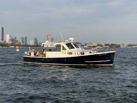 A lively group enjoys a celebration aboard a boat, with a stunning city skyline in the background — perfect for memorable gatherings on the water.
