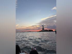 A stunning sunset view of the Statue of Liberty from a boat, capturing the essence of a memorable trip on the water.