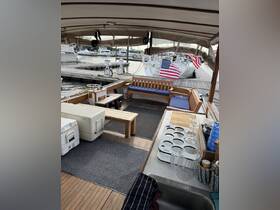 A cozy interior view of a boat featuring comfortable seating and a well-equipped helm area, perfect for relaxing or entertaining while on the water.