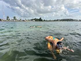 A child enjoys swimming and playing in the water, showcasing the fun of water activities during a sunny day — perfect for family outings.