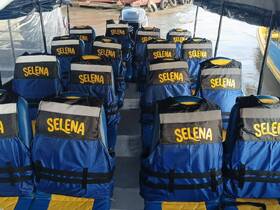 Interior view of a boat featuring neatly arranged seating with life jackets labeled 'SELENA' — perfect for ensuring safety during water adventures.