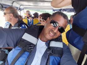 A group of guests enjoying a boat ride, all wearing life jackets, capturing the excitement of their adventure on the water.