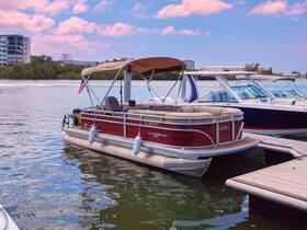 A beautiful red pontoon boat docked in calm waters, showcasing its spacious design and perfect for leisurely outings on the water.