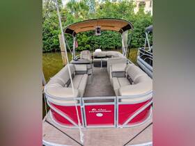 Interior view of a spacious Sun Tracker pontoon boat, featuring comfortable seating and a shaded area, perfect for relaxing on the water.